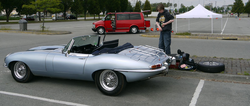 A pile of spares and duct tape rolls grows next to the Jaguar