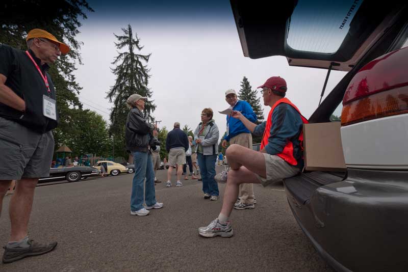 A rally Volunteer hands out route instructions at the REAL start of the event.